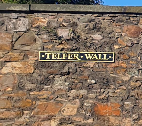 A brick and stone wall with the sight Telfer Wall